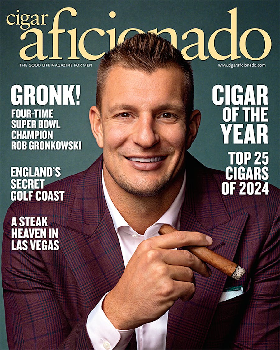 Magazine cover featuring a man holding a cigar with text about 'Cigar Aficionado' magazine.