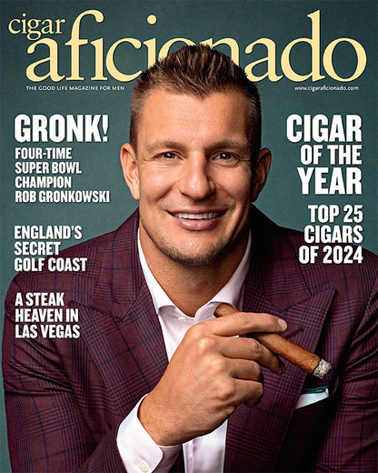 Magazine cover featuring a man holding a cigar with text about 'Cigar Aficionado' magazine.